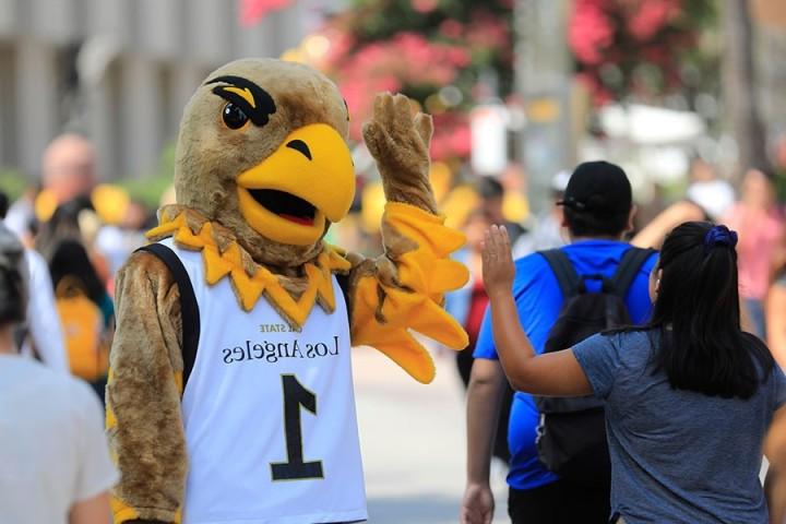 eddie the eagle high 5's student on walkway